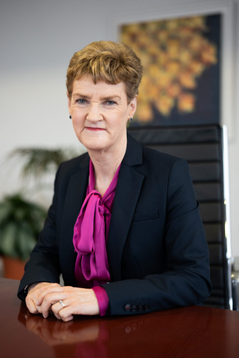 Photograph of Raylene Downes, legal costs specialist, seated at a boardroom table