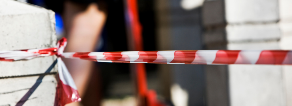 reporting workplace accidents - red and white striped safety tape cordons off an area