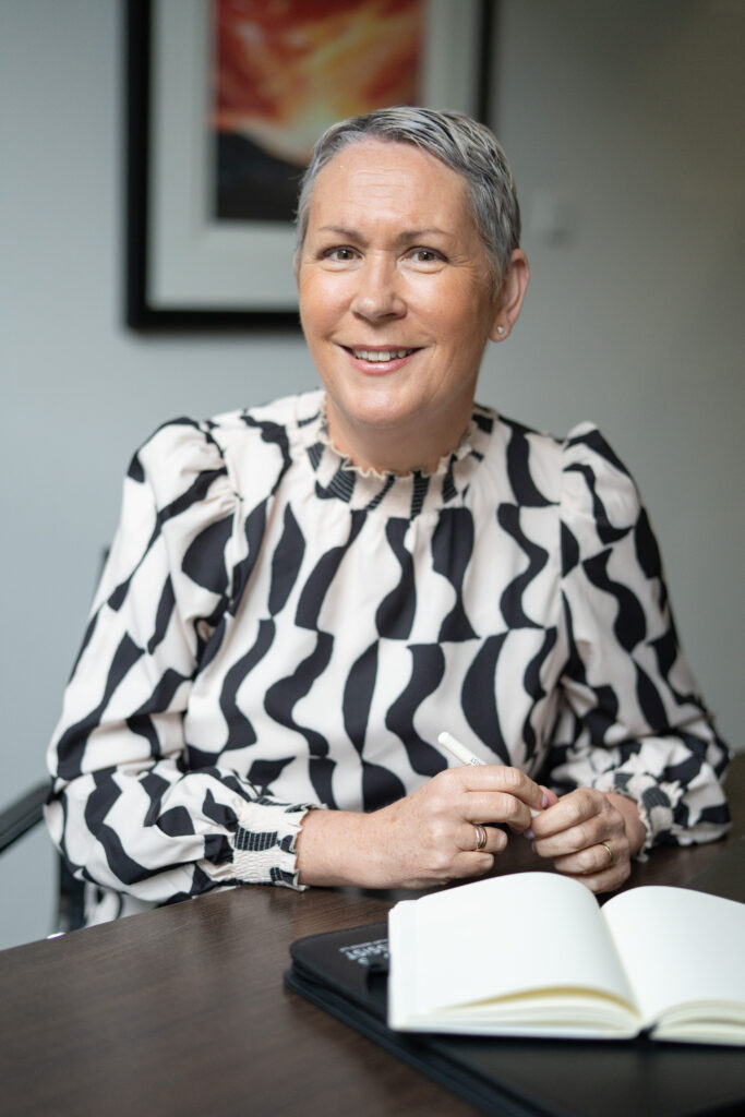 Photograph of Jane Shiels, Secretary sitting at boardroom table